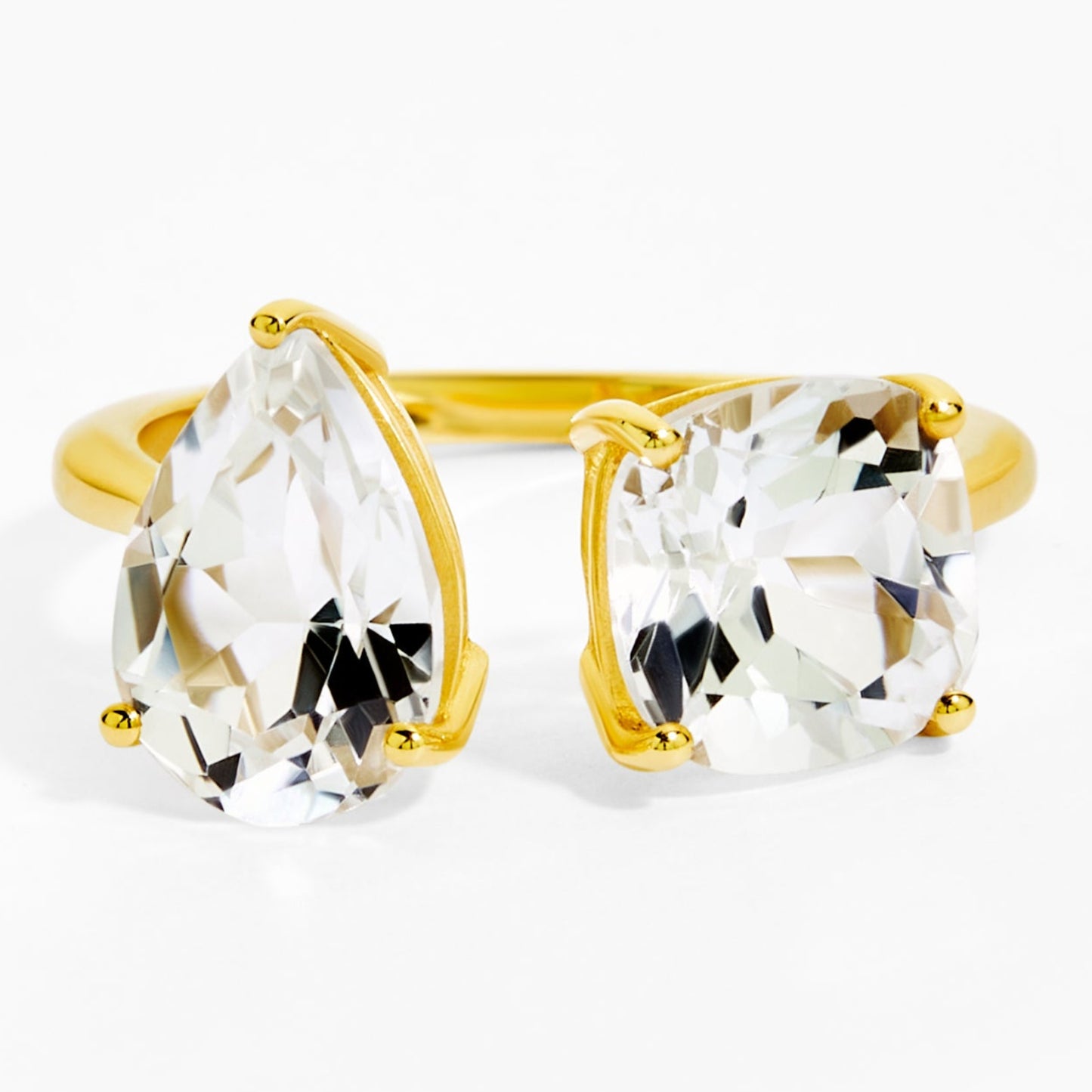 Gold ring with clear gemstones on a white background