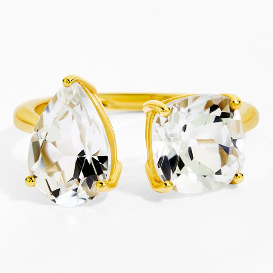 Gold ring with clear gemstones on a white background