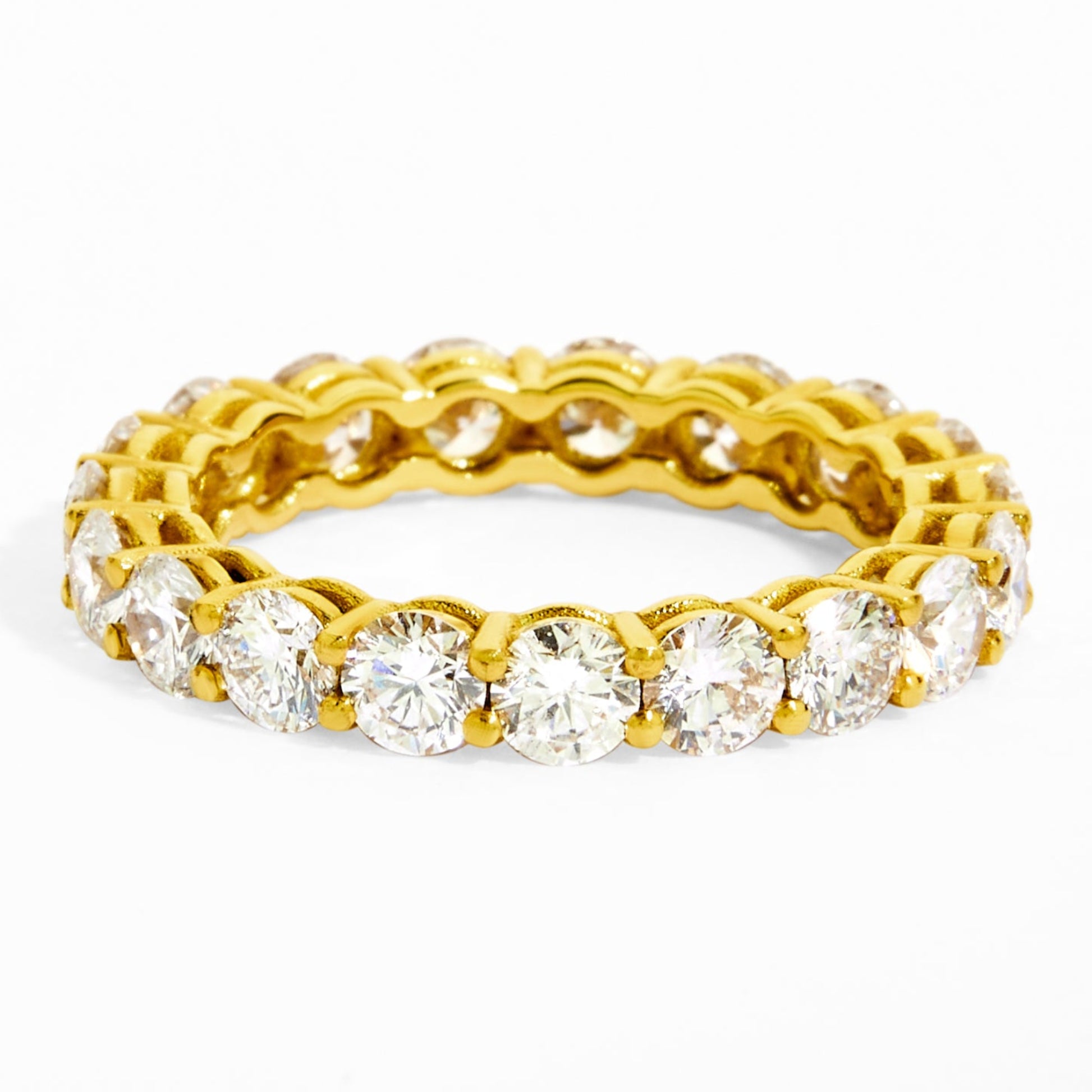 Gold ring with embedded diamonds on a white background