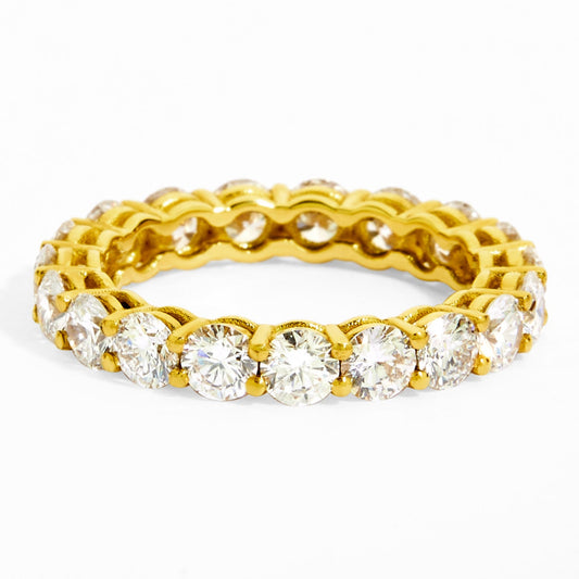 Gold ring with embedded diamonds on a white background