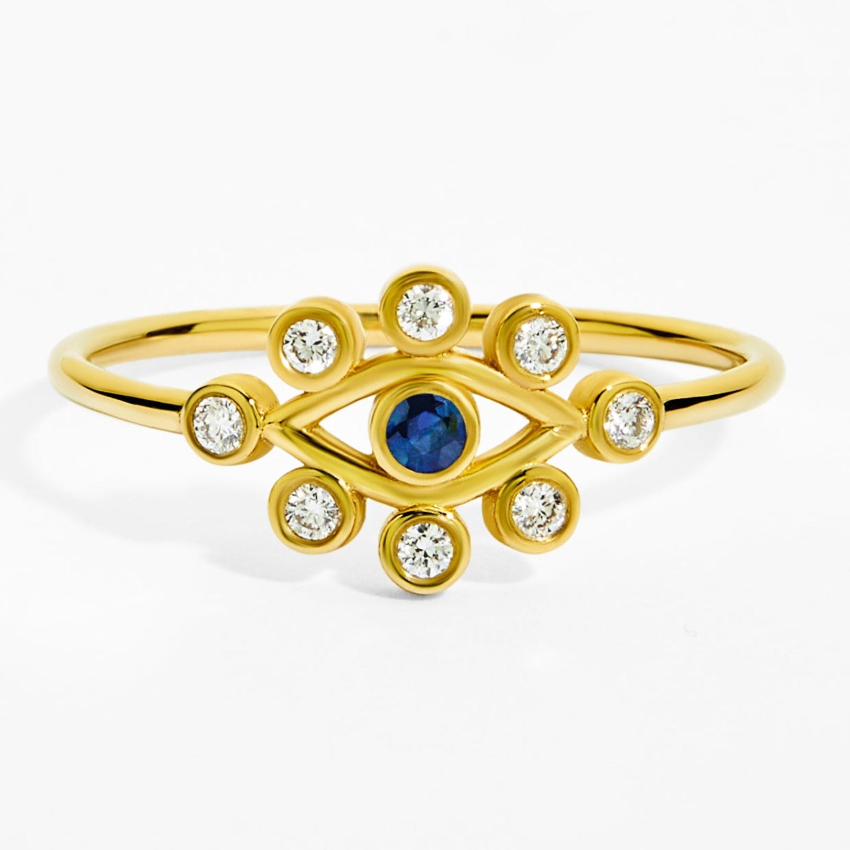 Gold ring with a blue gemstone and clear stones on a white background
