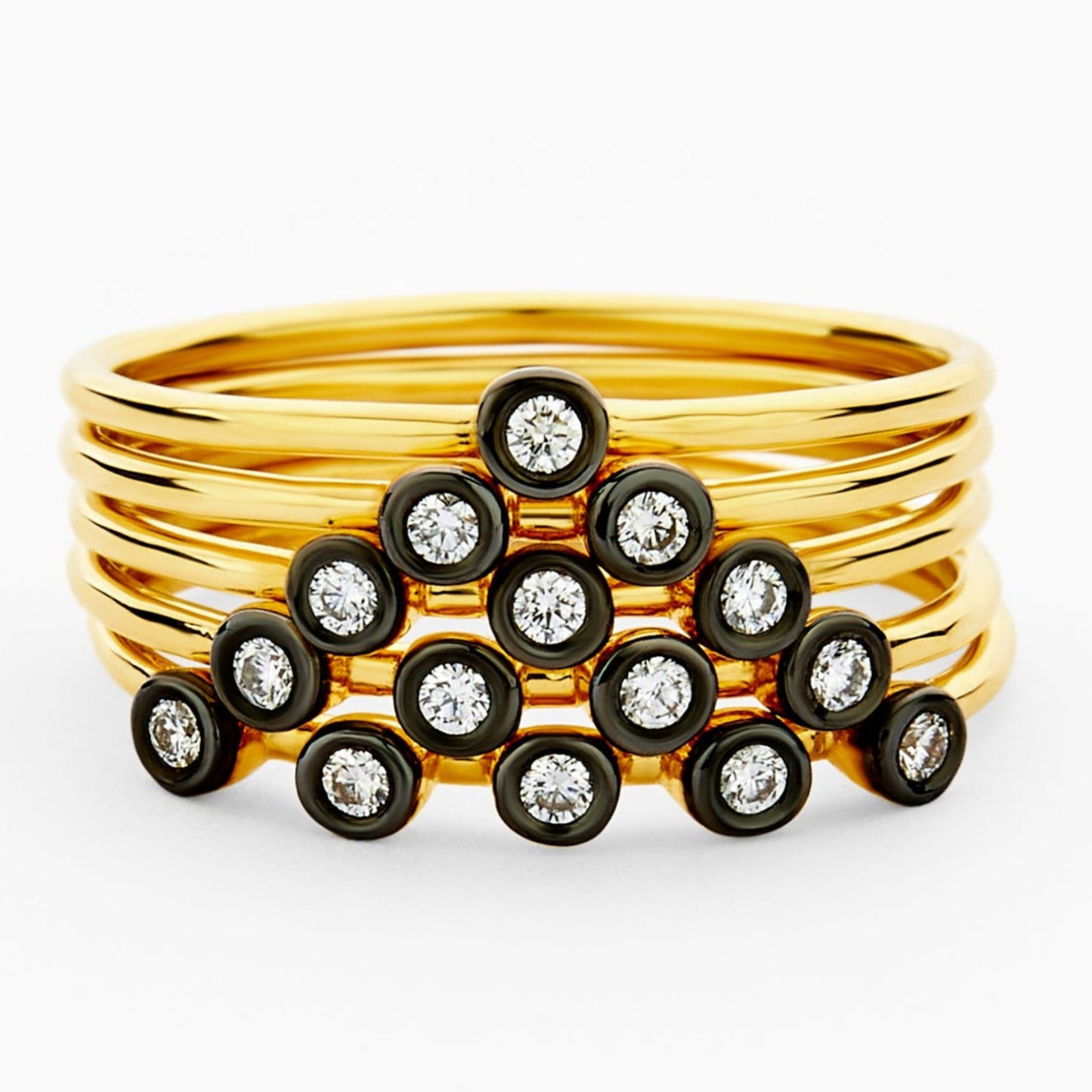 Gold ring with embedded black gemstones on a white background