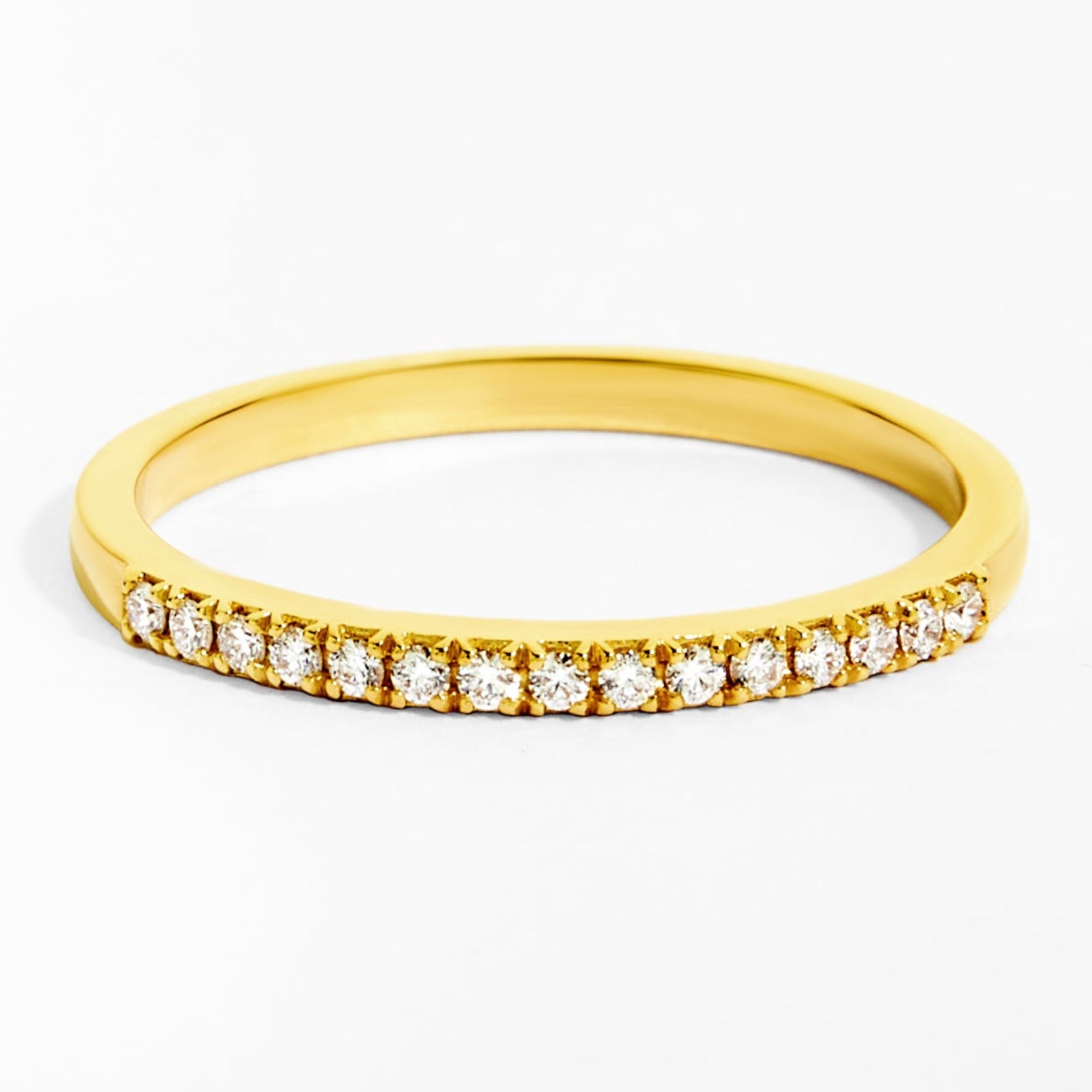 Gold ring with small diamonds on a white background