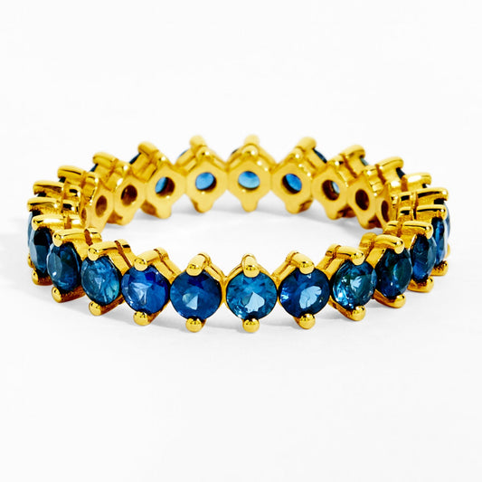 Gold ring with blue gemstones on a white background