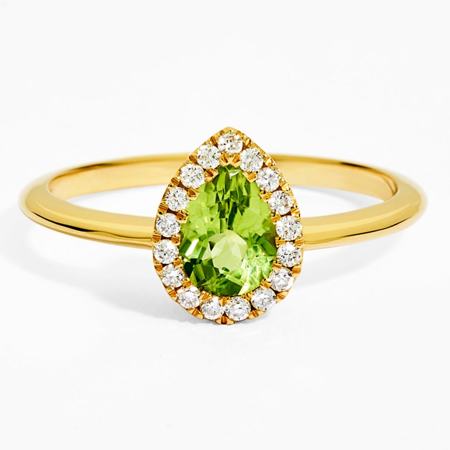 Gold ring with a green gemstone and diamond accents on a white background