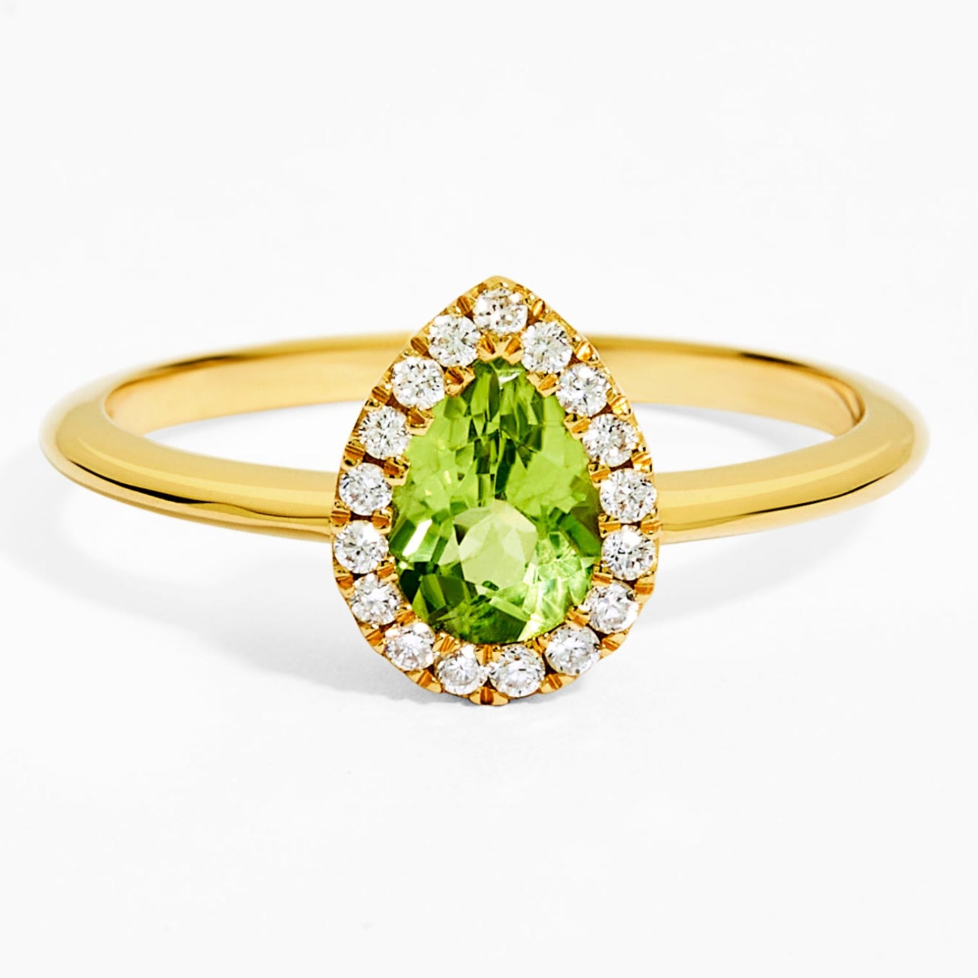 Gold ring with a green gemstone and diamond accents on a white background