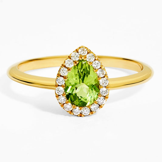 Gold ring with a green gemstone and diamond accents on a white background
