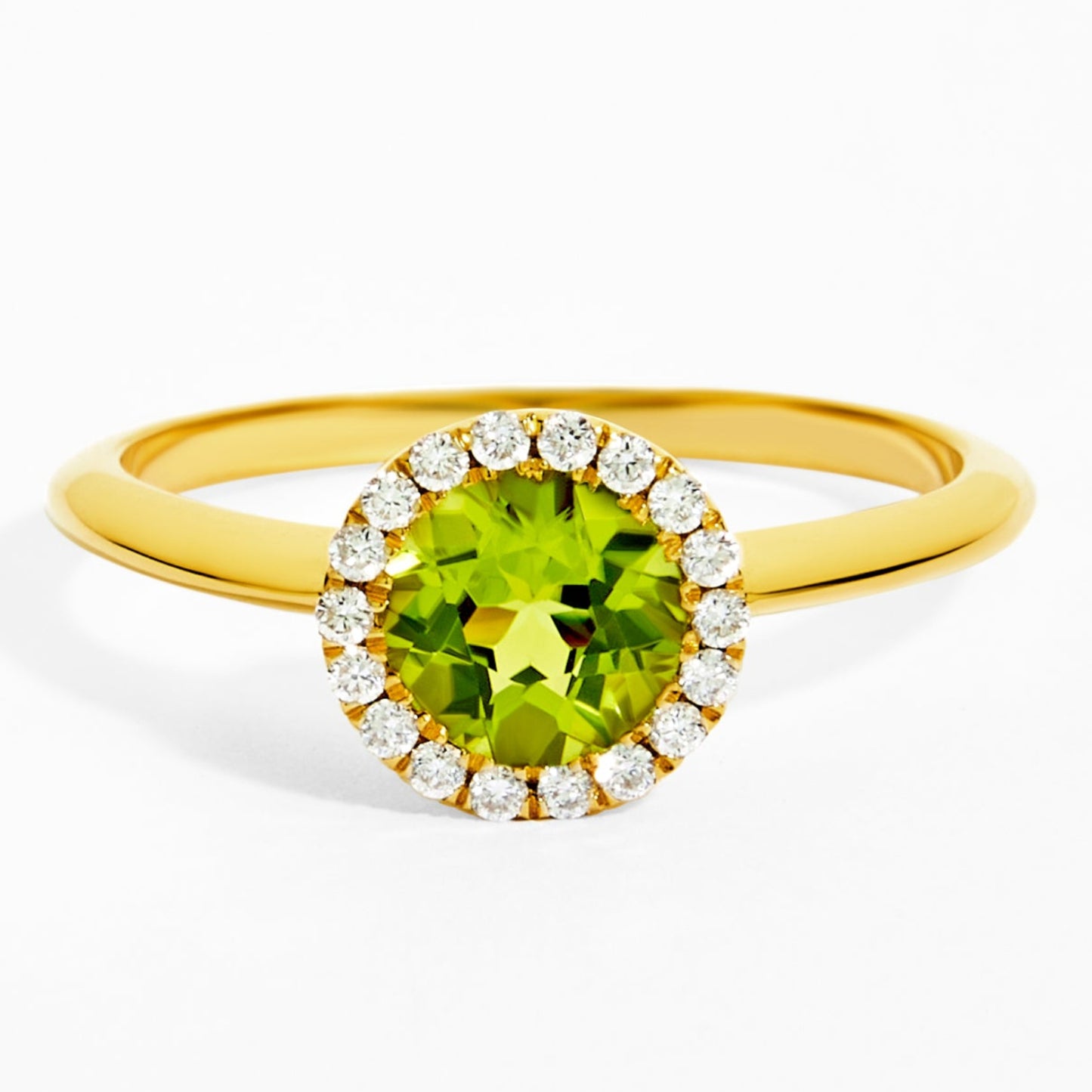 Gold ring with a green gemstone and diamond accents on a white background