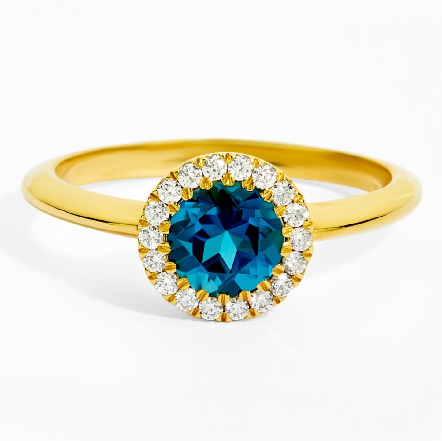 Gold ring with a blue gemstone and diamond accents on a white background