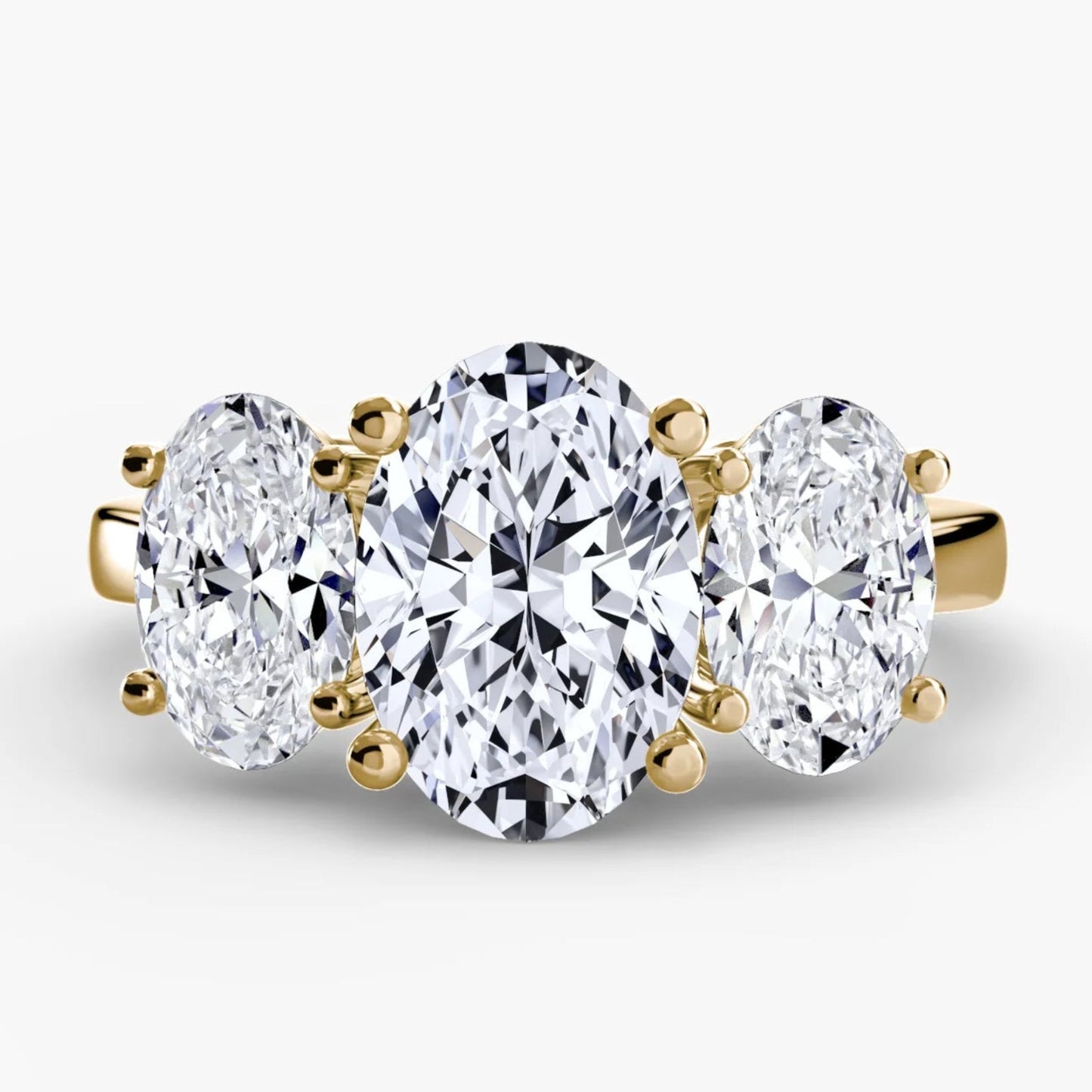 Three-stone diamond ring with gold setting on a white background