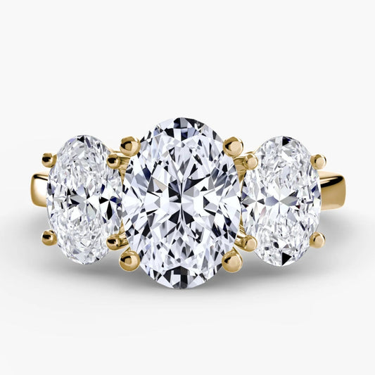 Three-stone diamond ring with gold setting on a white background