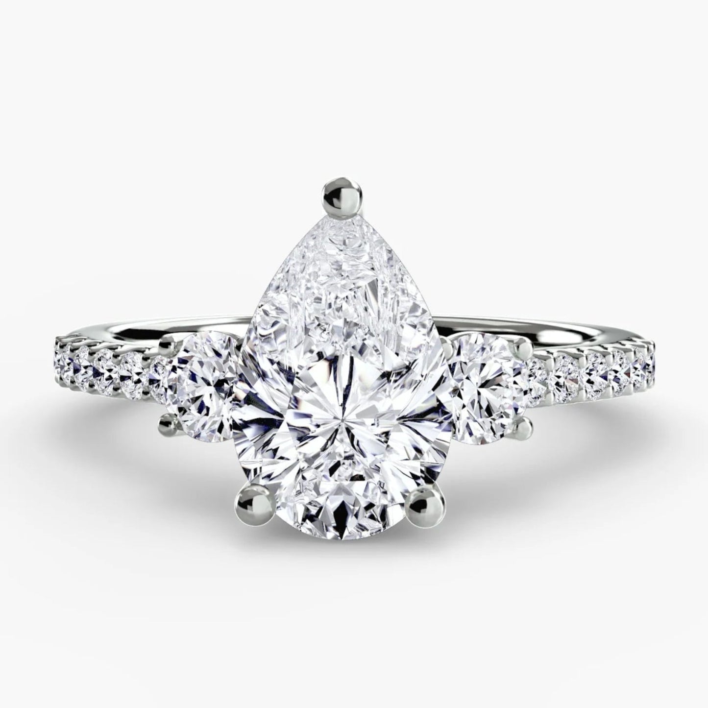 Diamond ring with a pear-shaped center stone on a white background