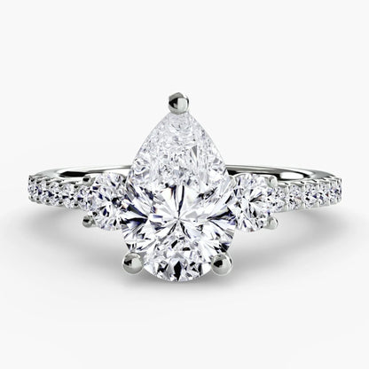 Diamond ring with a pear-shaped center stone on a white background