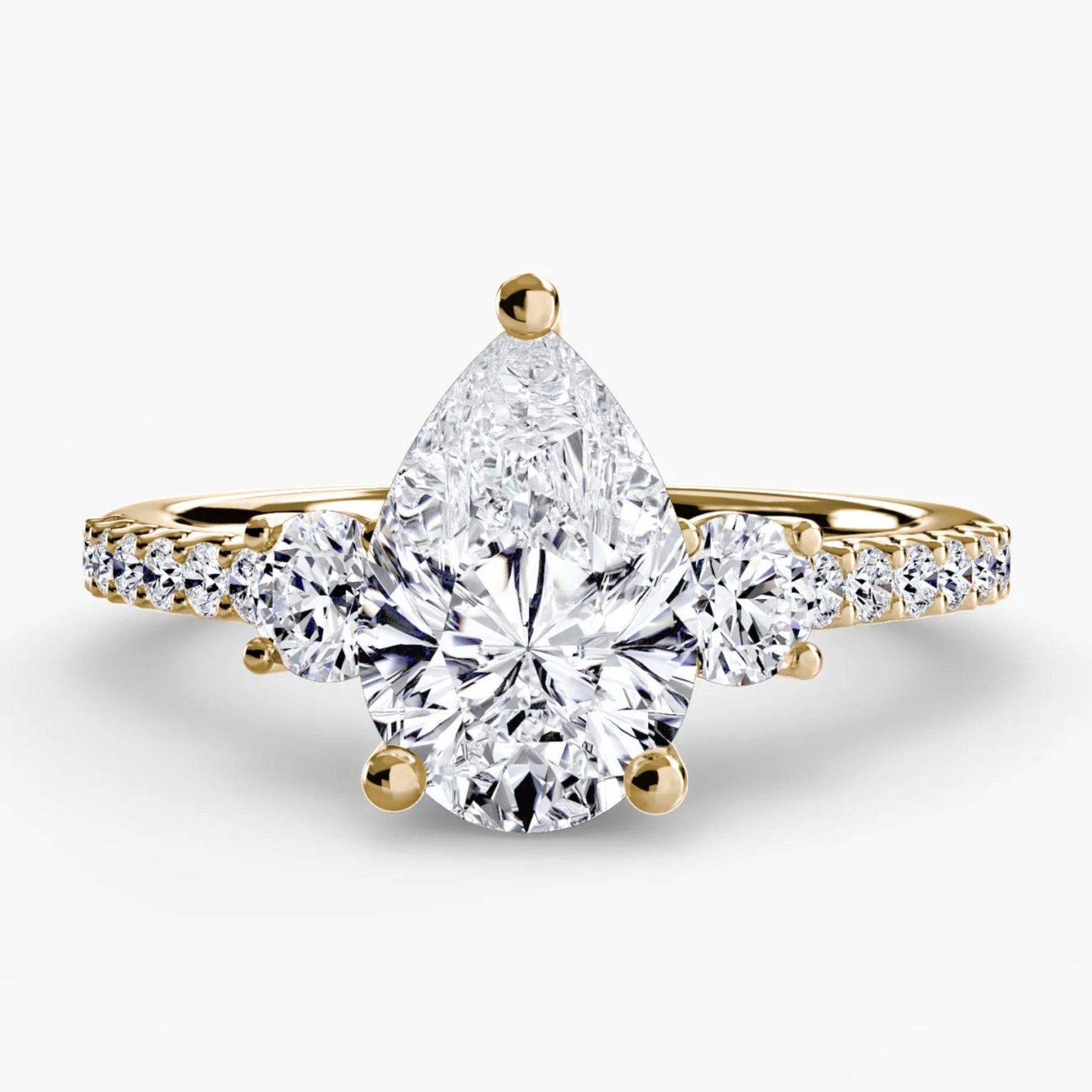 Gold ring with a pear-shaped diamond on a white background