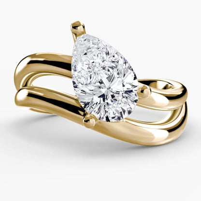 Gold ring with a pear-shaped diamond on a white background