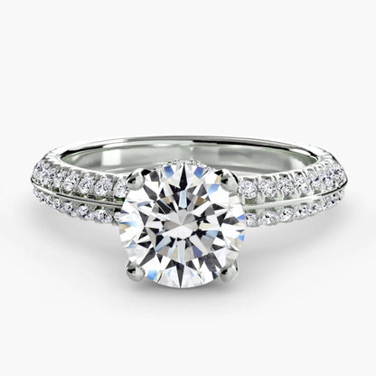 Silver ring with a large diamond and smaller diamonds on the band against a white background