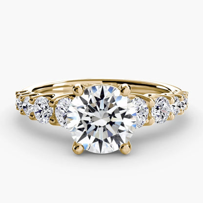 Gold ring with a large central diamond and smaller diamonds on the sides against a white background
