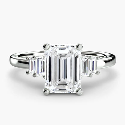 Diamond ring with emerald-cut center stone on a white background