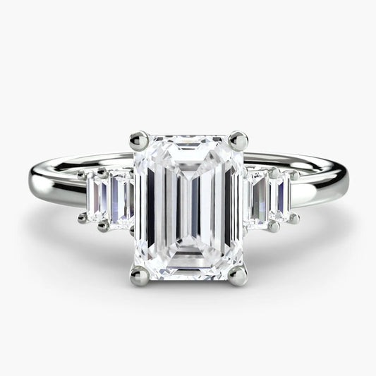 Diamond ring with emerald-cut center stone on a white background