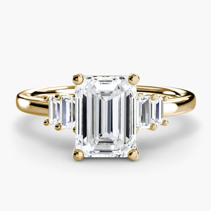 Gold ring with an emerald-cut diamond on a white background
