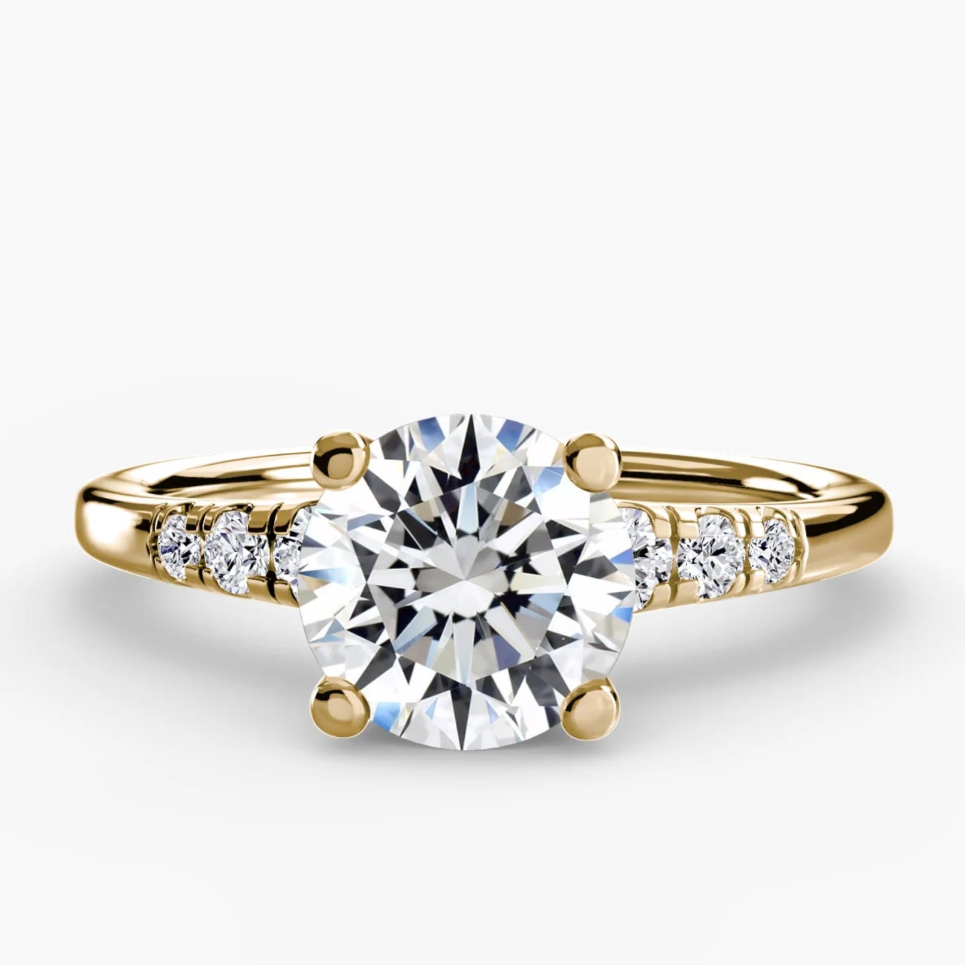 Gold ring with a large diamond and smaller diamonds on the band against a white background
