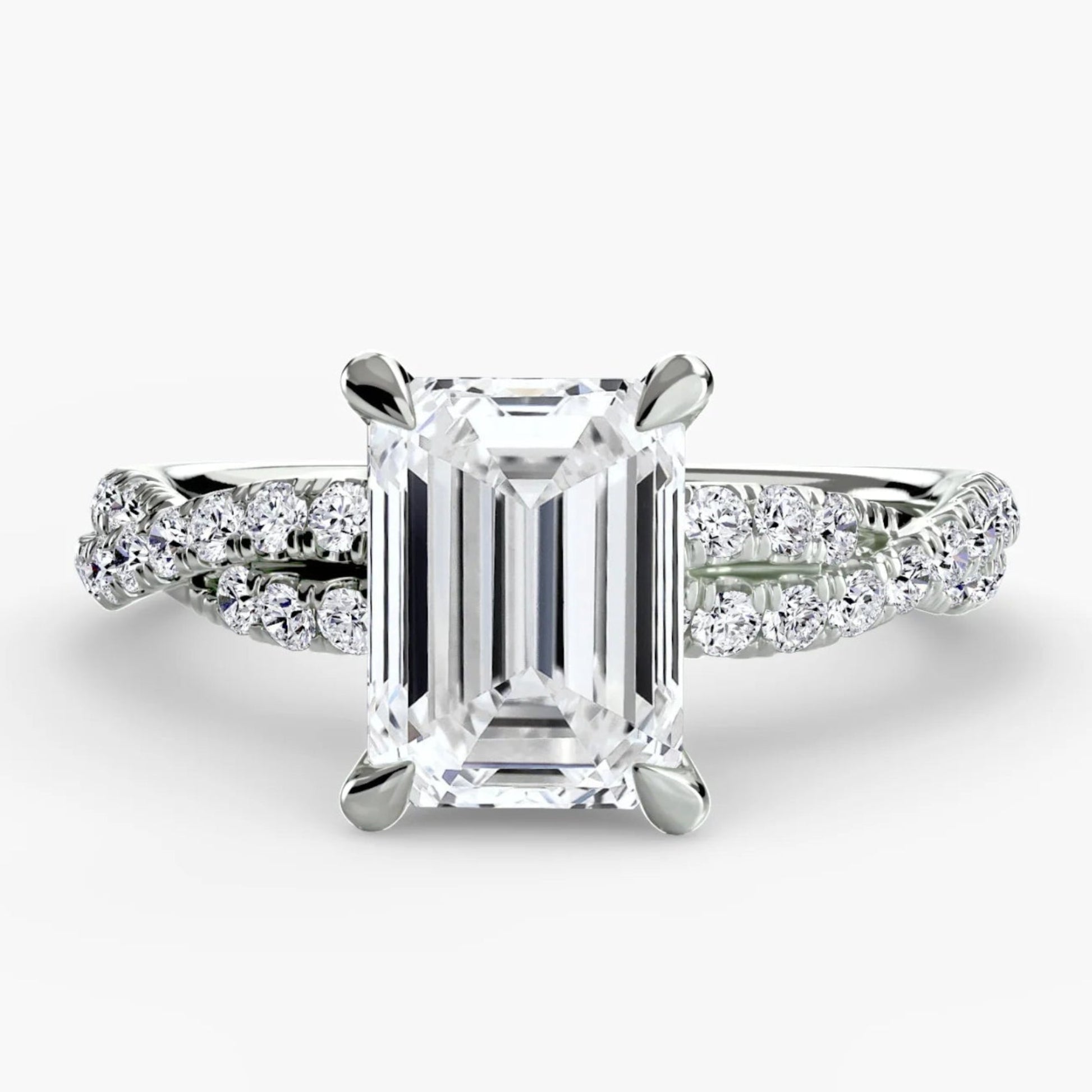 Diamond ring with emerald-cut center stone on a white background