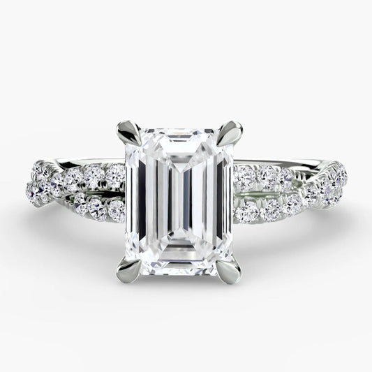 Diamond ring with emerald-cut center stone on a white background