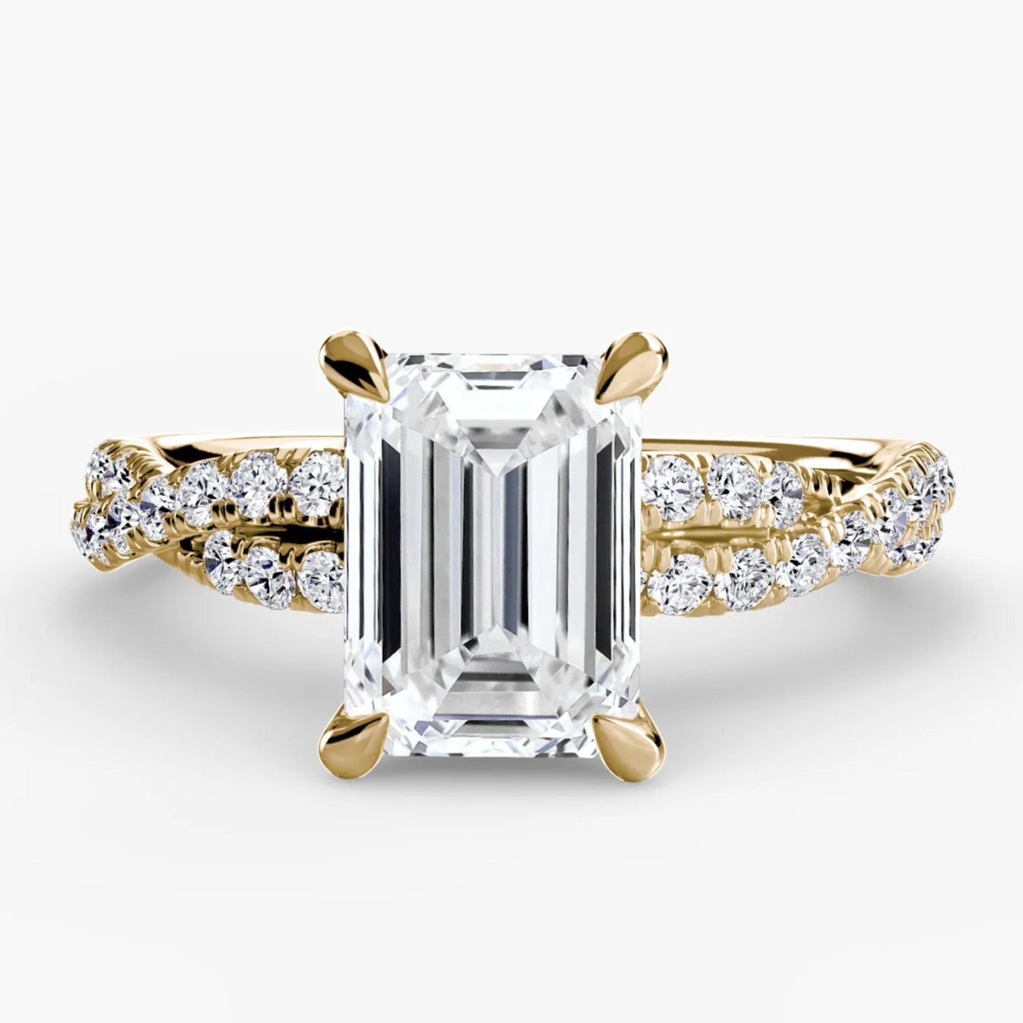 Gold ring with a large diamond and smaller diamonds on the band against a white background