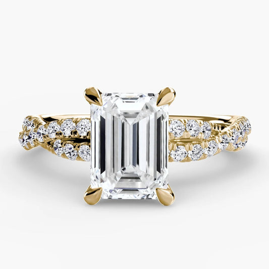 Gold ring with a large diamond and smaller diamonds on the band against a white background