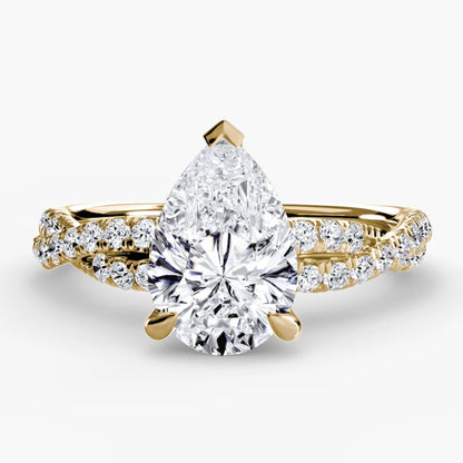 Gold ring with a pear-shaped diamond on a white background