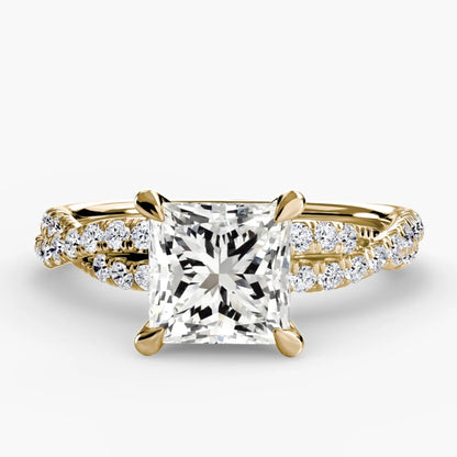 Gold ring with a large diamond and smaller diamonds on the band against a white background