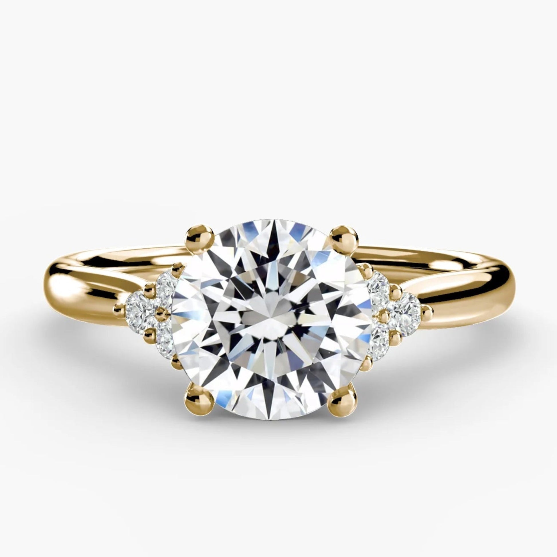 Gold ring with a large diamond and smaller diamonds on the band against a white background
