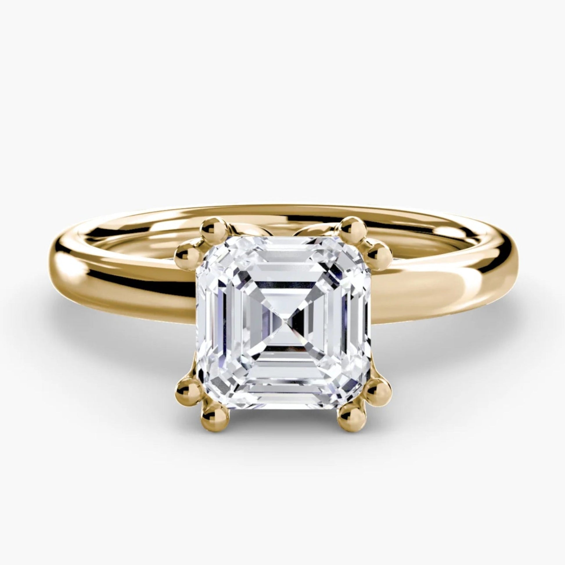 Gold ring with a square-cut diamond on a white background