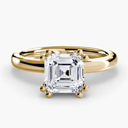 Gold ring with a square-cut diamond on a white background