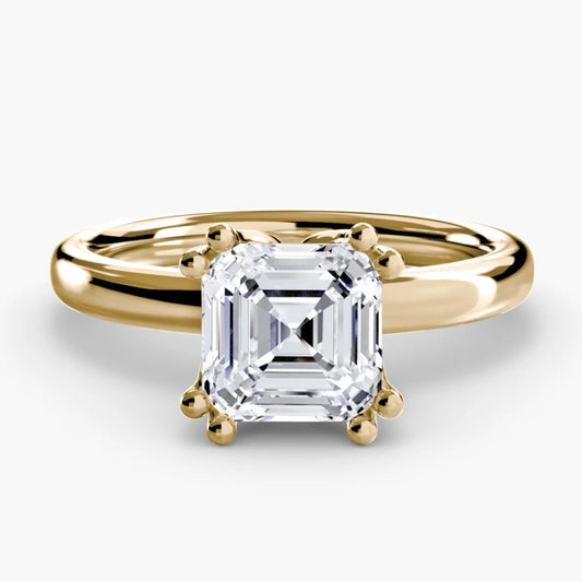 Gold ring with a square-cut diamond on a white background