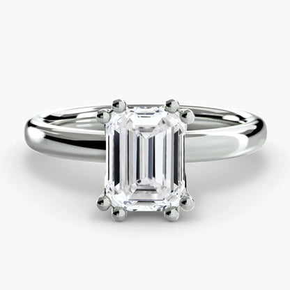 Diamond ring with emerald-cut gemstone on a white background