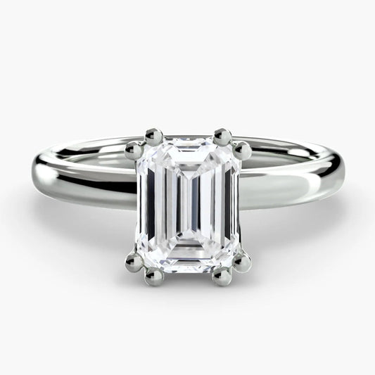 Diamond ring with emerald-cut gemstone on a white background