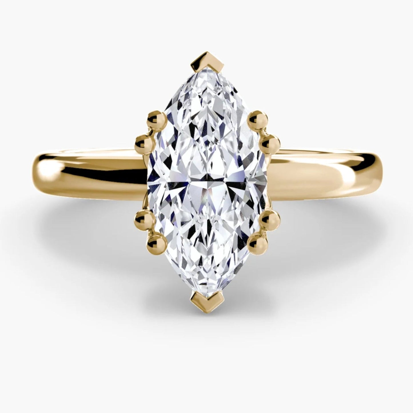Gold ring with a marquise-shaped diamond on a white background