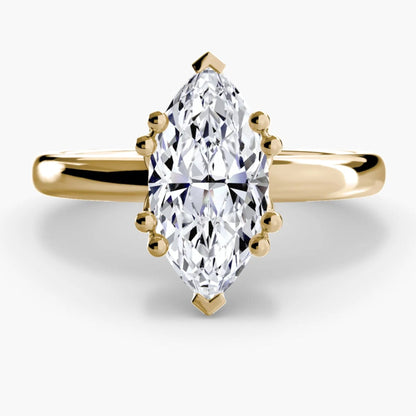 Gold ring with a marquise-shaped diamond on a white background