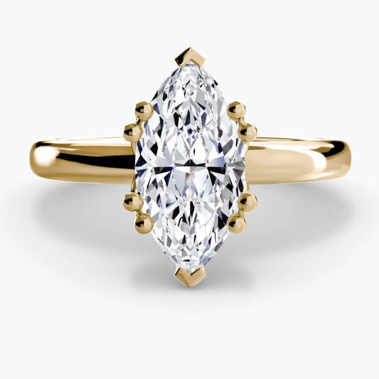Gold ring with a marquise-shaped diamond on a white background